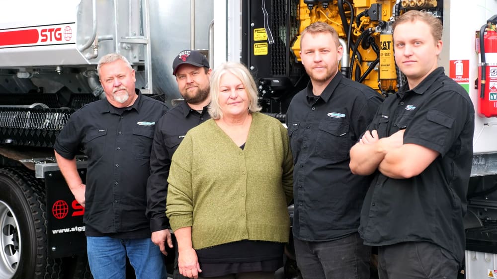 The PS Equipment team in front of a concrete pump truck.